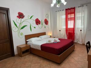 罗马Oderisi crossroads的卧室配有一张挂着红色鲜花的床。