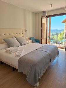 - une chambre avec un grand lit et un balcon dans l'établissement Hotel Vinoteca Alquezar - Adults Only -, à Alquézar
