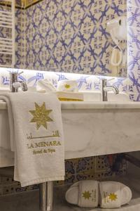 a bathroom with a white sink and a towel at La Menara Hotel & SPA in Sidi Bou Saïd