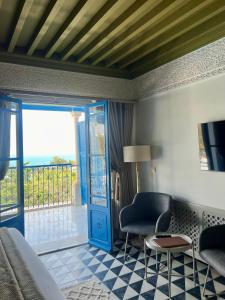 a bedroom with a bed and a door with a balcony at La Menara Hotel & SPA in Sidi Bou Saïd