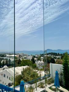 a view of a city from a balcony with umbrellas at La Menara Hotel & SPA in Sidi Bou Saïd