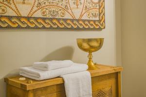 a pile of towels on a wooden table with a trophy at La Menara Hotel & SPA in Sidi Bou Saïd