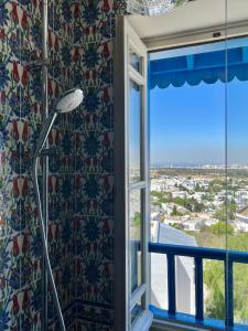 a shower in a room with a window at La Menara Hotel & SPA in Sidi Bou Saïd