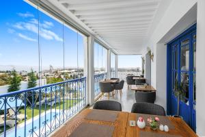a balcony with tables and chairs and large windows at La Menara Hotel & SPA in Sidi Bou Saïd