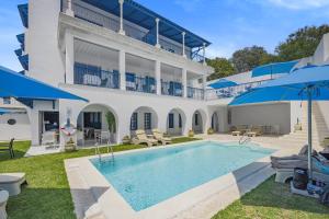 een groot wit huis met een zwembad bij La Menara Hotel & SPA in Sidi Bou Saïd