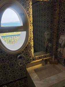 a bathroom with a large sink and a window at La Menara Hotel & SPA in Sidi Bou Saïd