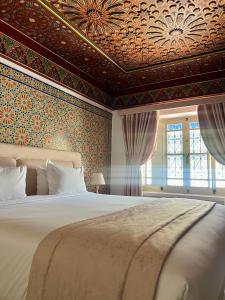 una camera con un grande letto e un soffitto a cassettoni di La Menara Hotel & SPA a Sidi Bou Saïd