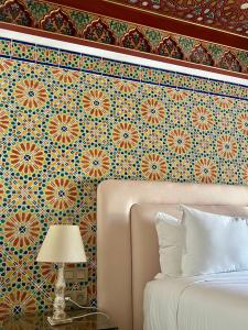 a bedroom with a wall with a floral wallpaper at La Menara Hotel & SPA in Sidi Bou Saïd