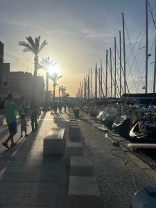 a group of people walking along a dock with boats at Dimora del Sole in Brindisi