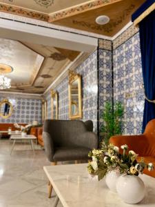a living room with a couch and a table with flowers at La Menara Hotel & SPA in Sidi Bou Saïd