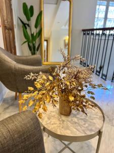 a vase with flowers on a table with two chairs at La Menara Hotel & SPA in Sidi Bou Saïd