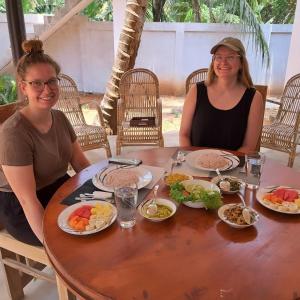 two women sitting at a table with plates of food at Kottamba Yala Stay & Safari in Tissamaharama