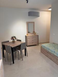 a room with a table and a bed and a mirror at Giglio di Mare Apartments in Rossano +18 photos