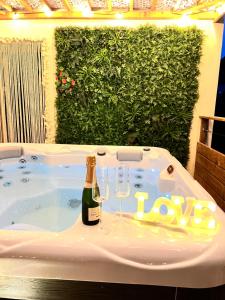 CantaronLOVE ROOM Tente Lodge spa MFG chez C&C, exclusivement réservée aux ADULTES的热水浴池,配有1瓶香槟和2杯