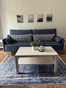 a living room with a blue couch and a coffee table at Madarász 3 Deluxe Vendégház in Balatonalmádi