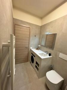 a bathroom with a sink and a washing machine at Giglio di Mare Apartments in Rossano