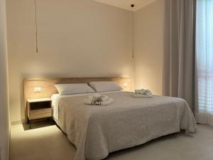 a bedroom with a bed with towels on it at Giglio di Mare Apartments in Rossano