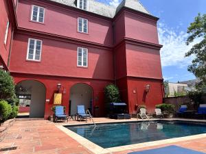 紐奧良的住宿－法國區黎塞留酒店，一座红色的建筑,前面设有一个游泳池
