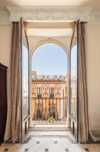 een open raam met uitzicht op een gebouw bij Lujoso apartamento a los pies de la Catedral in Sevilla