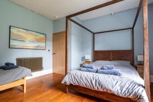 a bedroom with a large bed with blue pillows at Holmfield House in Clayton West