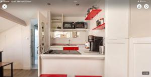 eine Küche mit weißen Geräten und roten Akzenten in der Unterkunft Studio atypique central mais calme, quartier VIP, plage 50m in Nizza + 47 Fotos