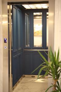 a blue door with a window and a potted plant at La Menara Hotel & SPA in Sidi Bou Saïd