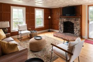 a living room with a fireplace and a tv at Quietude - A 60-Acre Historic Mountain Estate with 10 bedrooms in Tuftonboro