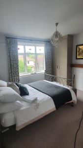 a bedroom with a bed and a window and a chandelier at The Homestay in High Wycombe
