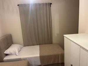 a small bedroom with a bed and a curtain at Apartments Smiljanic in Tribunj