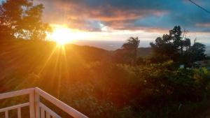 una puesta de sol en una colina con el sol en el cielo en Chalé Sitio Miranda Sra Solange, en Aratuba