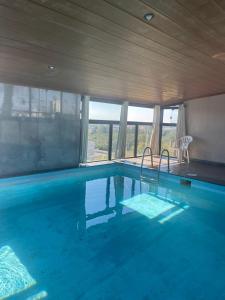 a large swimming pool with blue water in a house at Santa Catarina Plaza Hotel in Canoinhas