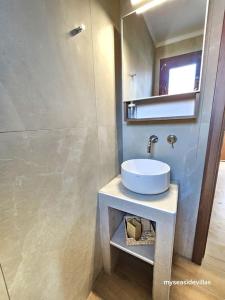 un baño con lavabo y espejo en Summertime Villa just 90meters from the sea!, en Sozopoli