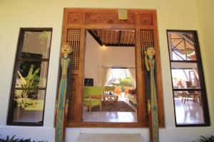 a room with a door with three mannequins at Kembali Villa in Kubutambahan