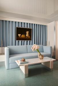 Una sala de estar con un sofá azul y una mesa. en Pied A Terre Arts et Métiers, en París