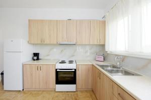 a kitchen with wooden cabinets and a stove and a sink at Emerald Private Villa in Kalavarda Rhodes in Kalavárda