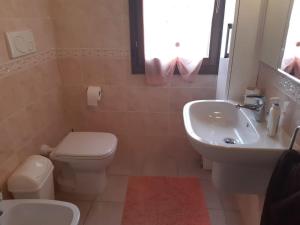 Un baño con un inodoro blanco y un lavabo. en Casa Costa Rei Villasimius, en Olìa Speciosa 17 fotos más