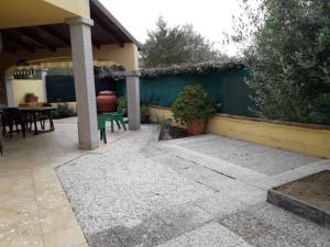 un patio con una valla verde y una mesa en Casa Costa Rei Villasimius, en Olìa Speciosa