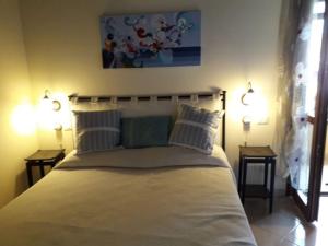 Un dormitorio con una cama grande con dos mesitas de noche. en Casa Costa Rei Villasimius, en Olìa Speciosa