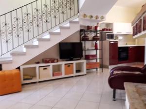 sala de estar con TV y escalera en Casa Costa Rei Villasimius, en Olìa Speciosa