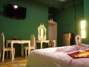 1 dormitorio con cama, mesa y espejo en Casacool Hotel, en Khao Lak