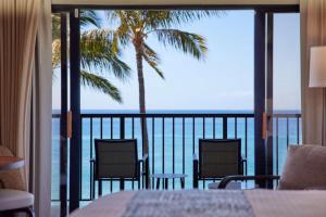 vistas a un balcón con 2 sillas y una palmera en OUTRIGGER Kāʻanapali Beach Resort, en Lahaina