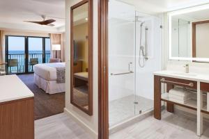 a bathroom with a shower and a bedroom with a bed at OUTRIGGER Kāʻanapali Beach Resort in Lahaina