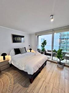 a bedroom with a large bed and a large window at Fantástico estudio en CLC in Santiago +25 photos