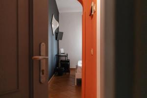 a hallway with an orange door leading to a bedroom at Mami Sabaudia Hotel in Sabaudia