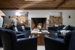 a living room with blue couches and a table at Hotel Villa Irma in Merano