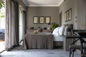 a bedroom with a bed and a table in it at Hotel Villa Irma in Merano