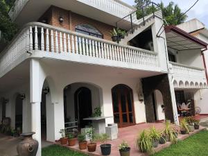 Casa blanca con escalera y macetas en Murphy's Villa en Katunayaka
