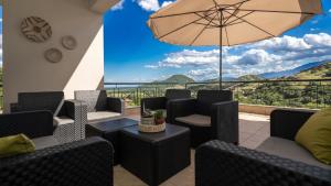 a patio with chairs and an umbrella with a view at "LaGo Village House" Family & Group Retreat near Meteora in Kalabaka