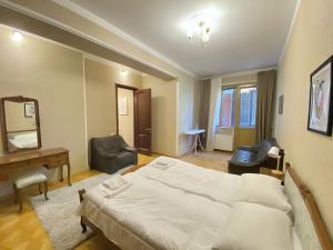トビリシにあるKing-size Apartment in the Heart of Tbilisiのベッドと机と鏡のある寝室