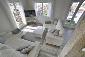 a living room with white furniture and large windows at Mirador de Siloé in Granada